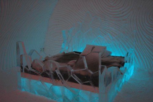 Ein Bett im Eishotel. Das halbdurchsichtige Zeug um das Bett herum ist kein Glas, sondern Eis!